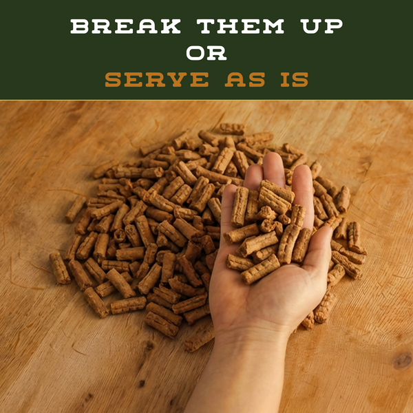Hand holding pet food pellets with text 'Break them up or serve as is' on a wooden surface